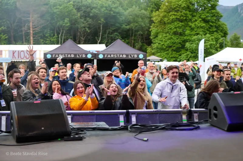 Publikum foran scenen på Laavfest 2026, med teltene og de grønne liene bak