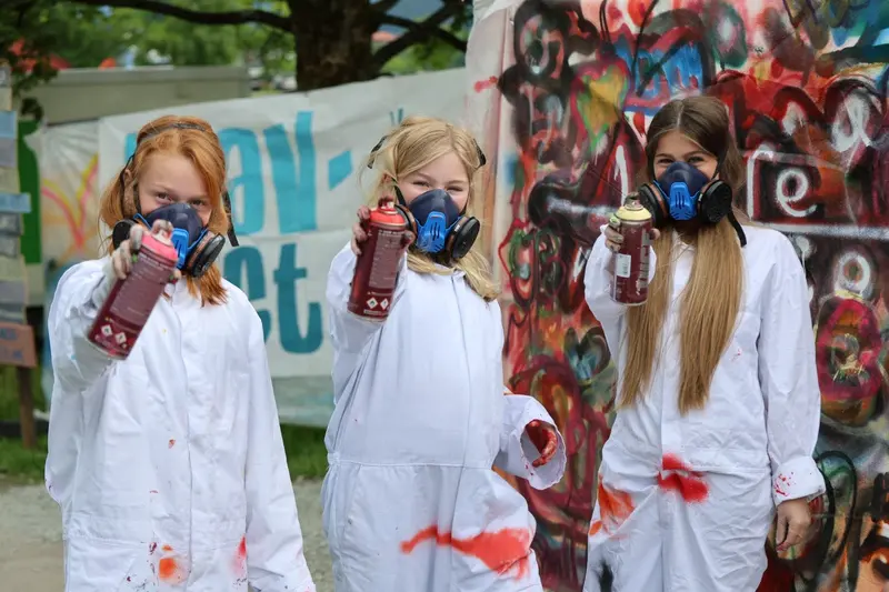 Barn i hvite dresser og masker lager graffiti